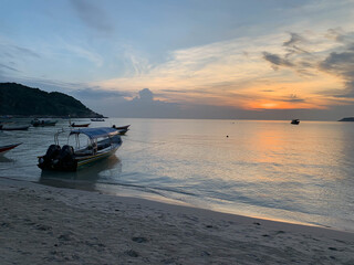 Sunrise and docked boats at Perhentian Island beach Malaysia