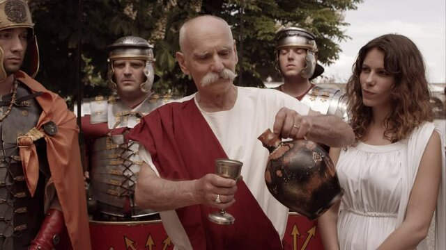 Roman Man Pours Wine From Amphora And Offers It To Somebody