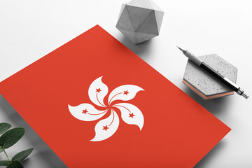 Hong Kong flag on minimalist paper background. National invitation letter with stylish pen on stone. Communication concept.