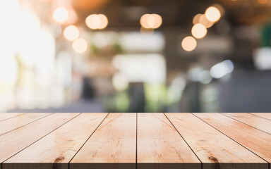 Empty wooden table top with lights bokeh on blur restaurant background. You can mock up your product
