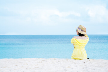 Fototapeta na wymiar 夏のビーチと黄色いワンピースの女性