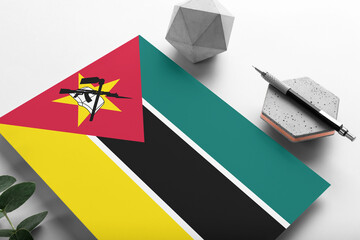 Mozambique flag on minimalist paper background. National invitation letter with stylish pen on...