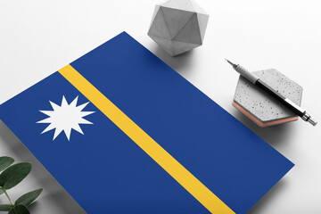 Nauru flag on minimalist paper background. National invitation letter with stylish pen on stone....