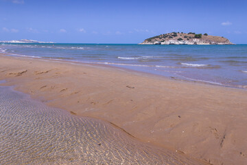Summertime relax.The most beautiful coasts of Italy: bay of Vieste, (Apulia, Gargano). In the foreground the Gattarella islet and in the background the town of Vieste.