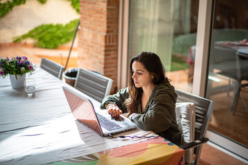 Young pretty woman with black hair studying for university and working using the laptop on a table...