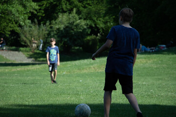Kinder laufen und Ball spielen auf Gras