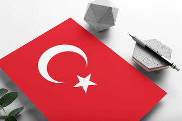 Turkey flag on minimalist paper background. National invitation letter with stylish pen on stone....