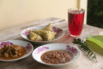 Ketupat (rice dumpling) served with red syrup,meat curry and peanut sause is a popular or signature dish made from rice packed. It usually served during festive season of Eid Mubarak / Ied Fitr or ram