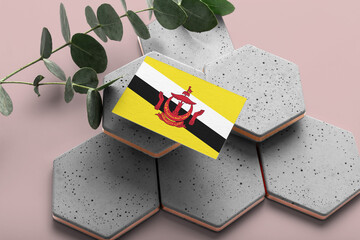 Brunei flag on hexagon stylish stones. Pink copy space background. Flat lay, top view minimal national concept.