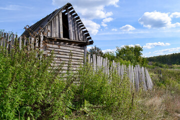 Fototapeta na wymiar an old barn and fence on the outskirts of the village