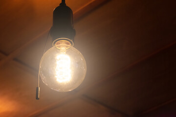Spheric old fashioned light bulb is hanging on the ceiling. Concept of having idea and inspiration....