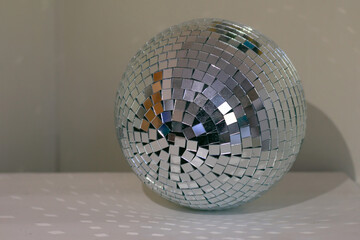 Shining disco ball with a lot of sparkles on table in room as home decor. Cosy home concepr details