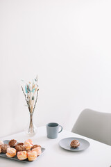 Cup of coffee with marshmallows and flowers on the table. Romantic morning. Tasty breakfast. Flat lay, top view, copy space.
