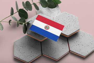 Paraguay flag on hexagon stylish stones. Pink copy space background. Flat lay, top view minimal national concept.