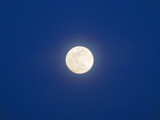 Full moon in a blue sky. The blue hour.