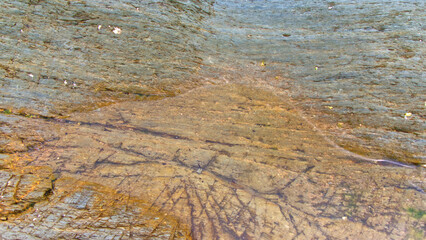 Rocks, pebbles, rock pools, sandsand ocean on an overcast June day in Cornwall