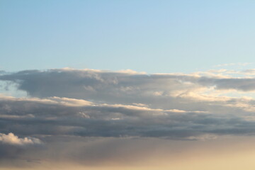White fluffy clouds on a background of blue sky in summer. The concept of weather and climate