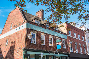 Exterior of renovated traditional Bristish brick buildings with shops on ground level on a sunny autumn day