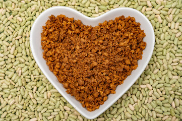 Love vegan and vegetarian food concept, plant based minced meat in heart shaped plate on soya beans background