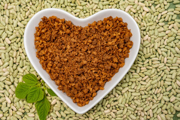 Love vegan and vegetarian food concept, plant based minced meat in heart shaped plate on soya beans background