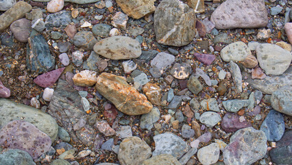 Textural backgrounds of beach pebbles, rocks and sand along the strand line of a sheltered Cornish beach.