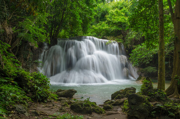 Fototapeta na wymiar Beautiful natural landscape scene of waterfall in rain forest with green trees in long exposure photography