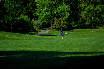 Kinder laufen und Ball spielen auf Gras