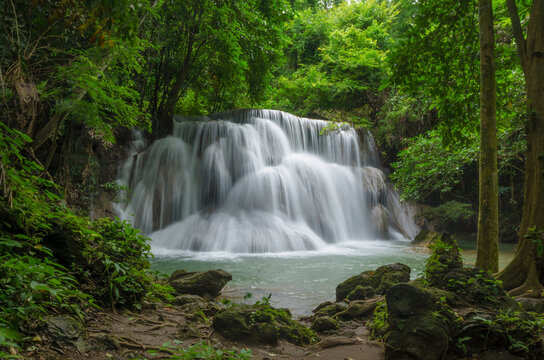 Beautiful natural landscape scene of waterfall in rain forest with green trees in long exposure photography