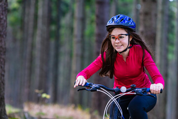 Obraz premium Healthy lifestyle - teenage girl biking in forest 
