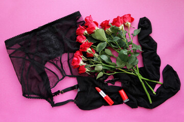 Sexy belt with stockings and red roses, red lipstick on pink background top view
