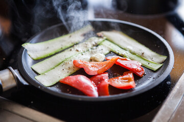 Slices of red bell pepper and zucchini prepared grill in a pan