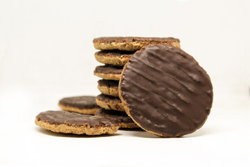 Chocolate coated whole wheat biscuits with added vitamins. Rounded cookies on white background isolated