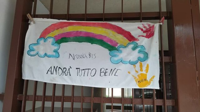 Turin, Piedmont, Italy. June 2020. Coronavirus pandemic. On the facades of the houses hang the sheets with the drawing of the rainbow and message everything will be fine. In Italian "Andr&agrave; tutto bene"