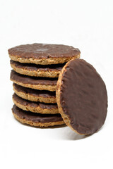 Chocolate coated whole wheat biscuits with added vitamins. Rounded cookies on white background isolated