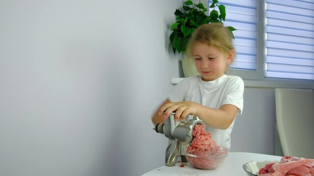 Cooking minced meat with a manual meat grinder. Close-up of front part of mincing-machine with mincemeat in. Showing the forcemeat process.