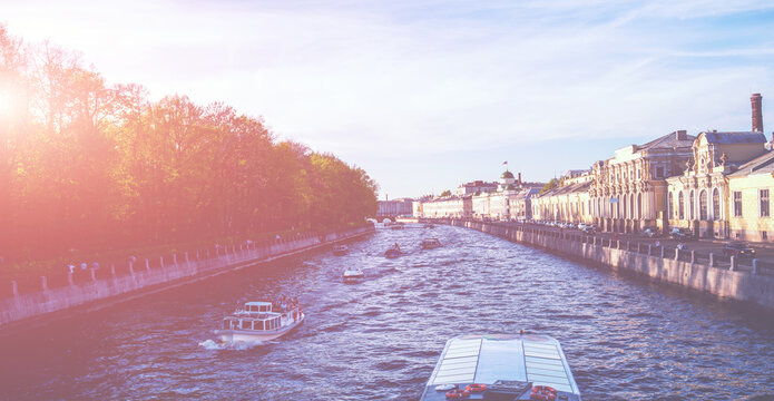 River channel with boats in Saint-Petersburg at sunset. St. Petersburg panorama with canals, historic buildings and beautiful architecture. Russia. Spring time. Travel inspiration.