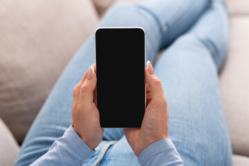 Workflow management and view of online training. Woman lies on sofa and holds smartphone