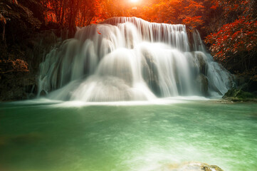 Beautiful waterfall with sunlight in autumn forest at Erawan National Park, Thailand, Nature landscape
