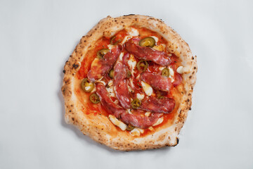 Italian pizza with pepper and jamon on a white background.