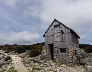 Kitchen hut, wooden hut has double story shelter  and one shovel in front of the hut . one of most famous  overland track in AUSTRALIA TASMANIA 