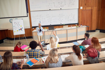 Students on a lecture in amphitheater - obrazy, fototapety, plakaty