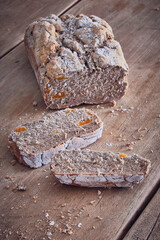rustic bread loaf sliced with apricot pieces on a rustic wooden table
