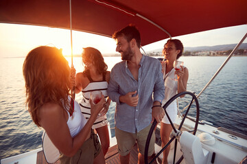 Friends  drinking on a yacht and enjoying at vacation and luxury travel at sunset..