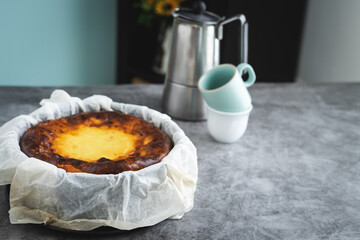 Cheesecake in marble background with coffee maker in the background. Copy space.