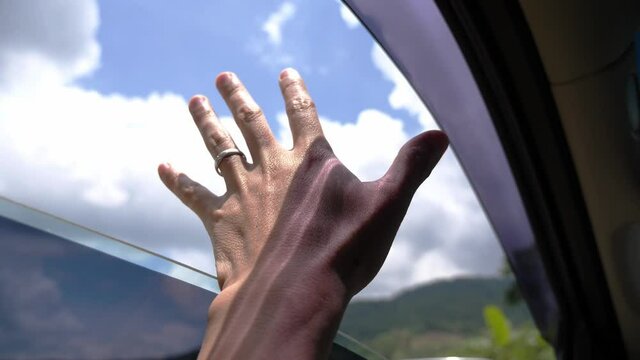 The hand and wind outside the car window, travel nature concept.