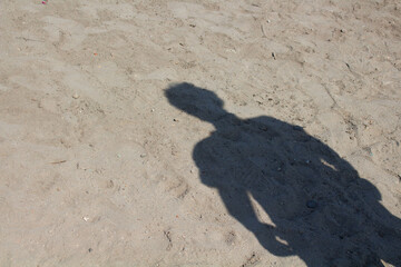 Man shadow on sand background.
