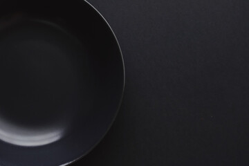 Empty plates on black background, premium dishware for holiday dinner, minimalistic design and diet...