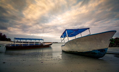 Fishing boats during low tide on cloudy day
