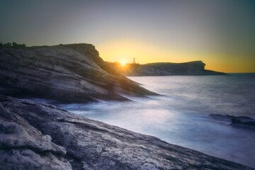 Obraz premium Sunset sky over sea and cliffs
