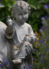 Obraz premium A statue of a child held by Jesus amongst wild flowers